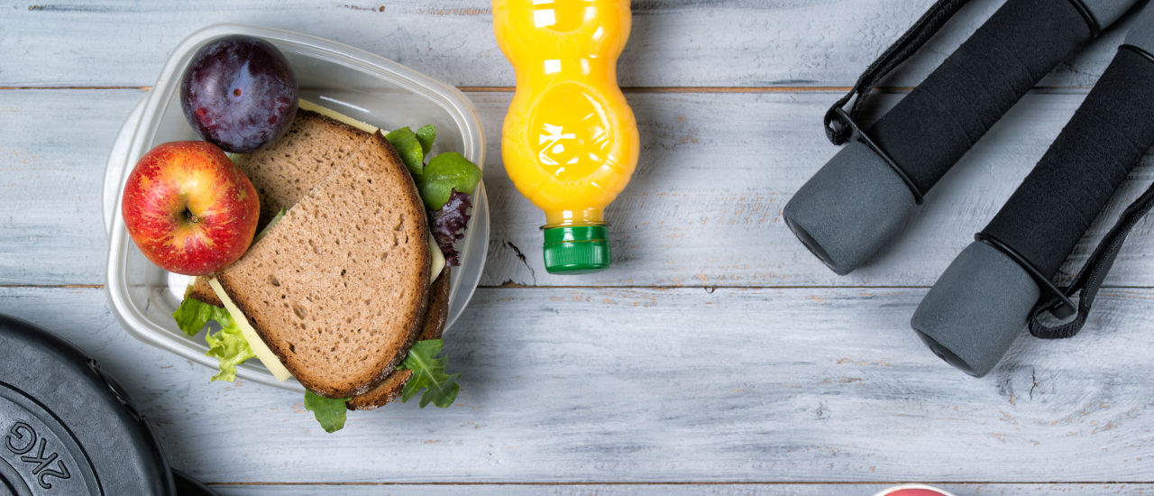 A healthy sandwich, juice, and weights. 