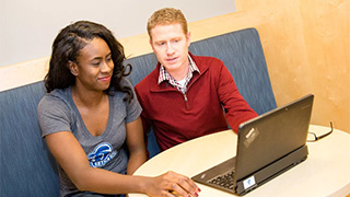 a picture of student-athlete with Matt Geibel sitting in front of a laptop