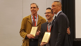 Michael Pasquier (at right), ACHA outgoing president, presents the award to Nicholas Rademacher (left) and Thomas Rzeznik (center).