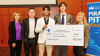 Anvillent team holding huge check