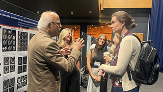 students and professor conference presentation