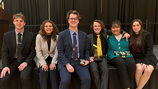 Amos Willey '26, Emily Vaca '26, Tristan Radcliffe '26, Bryce Leatham '25, Catherine Jones '26, and Karissa Kromminga '27, holding their quarter finalist and 19th place trophies.