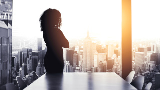 Business woman looking out window in conference room.