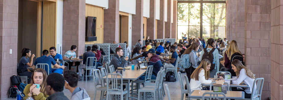 Students sitting at tables in the cafeteria. 