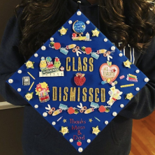 Decorated graduation cap with stickers related to teaching. 