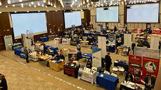 Students interacting with professionals from KPMG at the 2023 Career Expo.Students interacting with professionals at the 2023 Career Expo.Professionals preparing for students at the 2023 Career Expo.