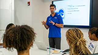 Carr seen presenting to the women's basketball team