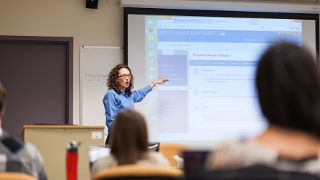 Teaching at the front of a classroom. 