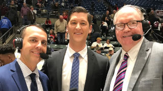 Photo of Clayton Collier on the sideline of a basketball game with other announcers