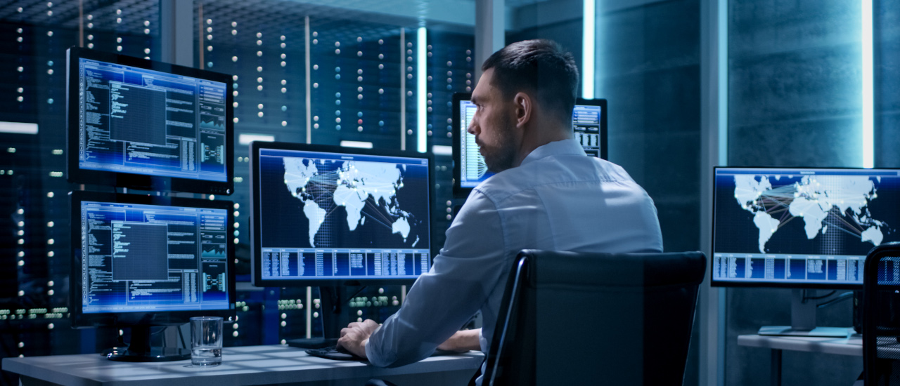 A photo of a man using computers.