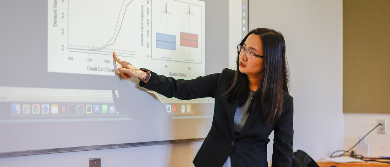 Professor giving a lecture about data mining to 3 students