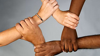 People from different cultures and backgrounds holding hands.