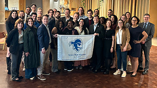 Students, faculty, and alumni pose for a photo