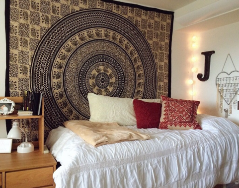 Photo of a dorm room with a tapestry on the wall. 