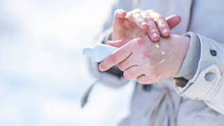 A person applying lotion on dry hands