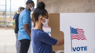 Young people, wearing masks, and voting in the election.