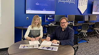 Stillman School of Business Dean Joyce Strawser signing Memorandum of Understanding with Catholic University of Lyon ESDES School of Business and Management Dean Olivier Maillard in the Center for Securities Trading and Business Analytics in Jubilee Hall.
