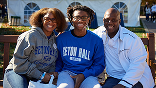 Family in Seton Hall clothes on bench