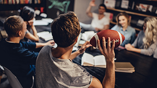 students around a table playing fantasy football