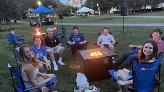 Students sitting around a fire pit on the University Green.