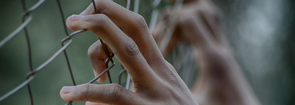 Hands on fence. 