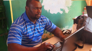 Man with a Hands Up For Haiti laptop