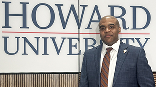 Hickman in front of a Howard University sign