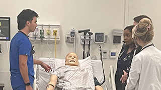 A B.S.N. student (left) practices clinical skills with a nurse practitioner student (right) in Seton Hall's simulation center.