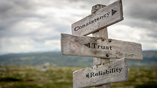 Directional sign post that reads consistency, trust, reliability.
