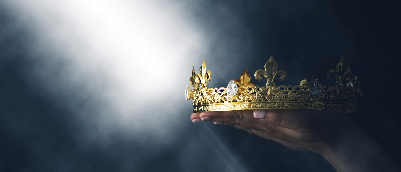 A hand holding a crown