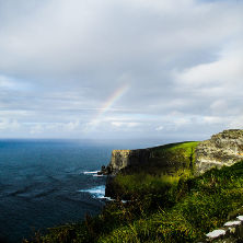 Overlooking cliffs in Ireland with a rainbow in the distance. - PIPE Presents Irish Language Workshop