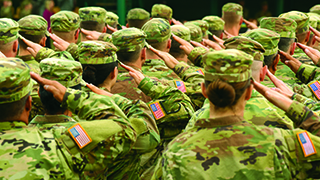 A group of military personnel in formation wearing uniforms and saluting.