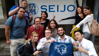 Students who participated in the Study Abroad program in Tokyo, Japan. The students are holding up a Seton Hall flag in the photo.