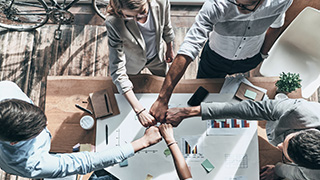 a picture taken from above shows five people putting their hands together in a fist pumb