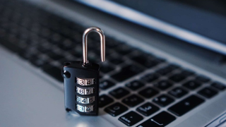 A combination lock on top of a laptop keyboard