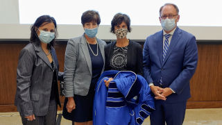 Lori Wilt standing with President Nyre and other faculty members