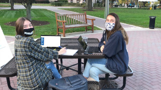 Students at picnic table in masks 