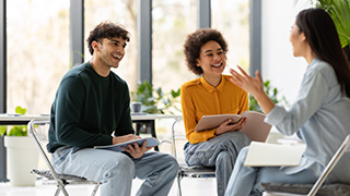 A mentor with students, engaged in conversation.