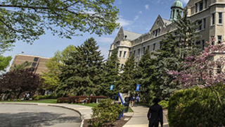 Person walking outside of Mooney Hall.