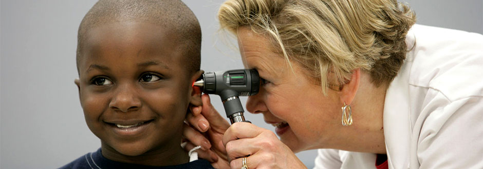 Female nurse examining a child's ear