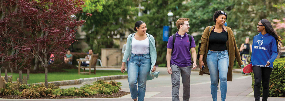 Students talking and walking on campus. 