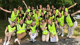 Graduate students in neon vests posing for picture