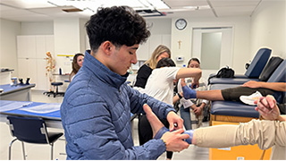 Pre-health student wrapping patient's foot