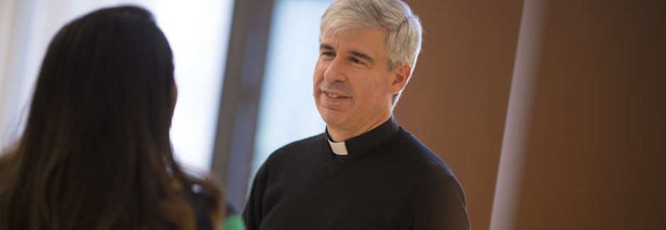 Priest speaking with student 