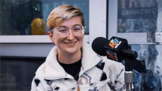 student posing for photo with microphone