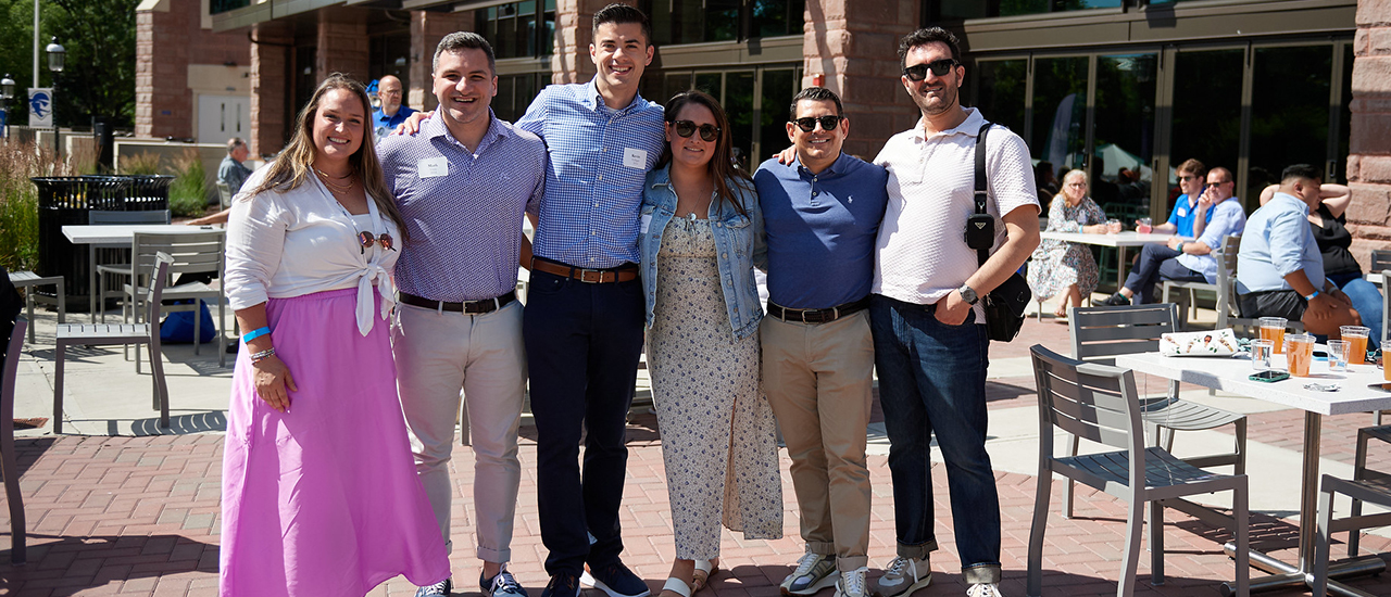 Previous Reunion attendees posing on campus with swag bags.