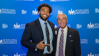 Michael standing next to a student