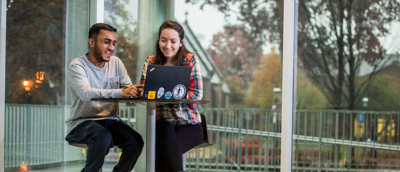 Two students working on a laptop. 