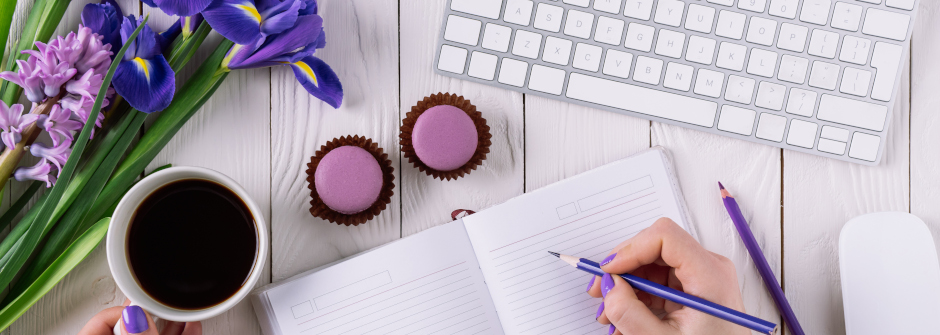 Cropped shot of woman writing in notebook at workplace stock photo