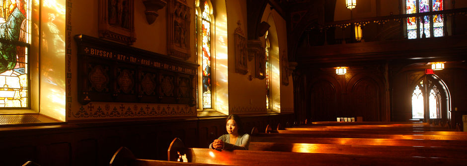 Student in a pew in the chapel.